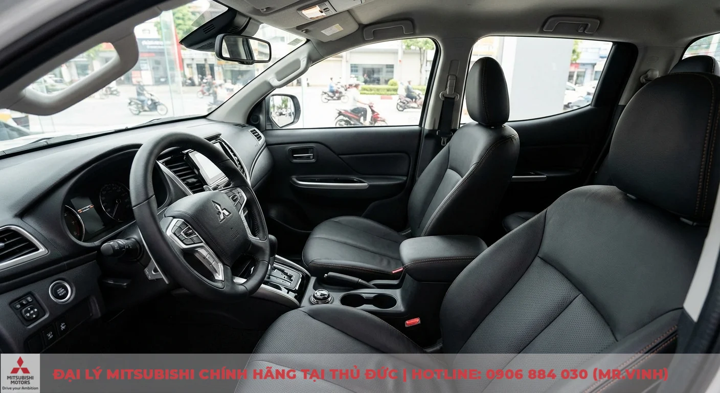 So sánh phiên bản Triton 2026: Khác biệt Athlete, Premium và GLX 3 Nội thất xe ô tô với ghế da màu đen, vô lăng có logo Mitsubishi, bảng điều khiển trung tâm và cần số tự động