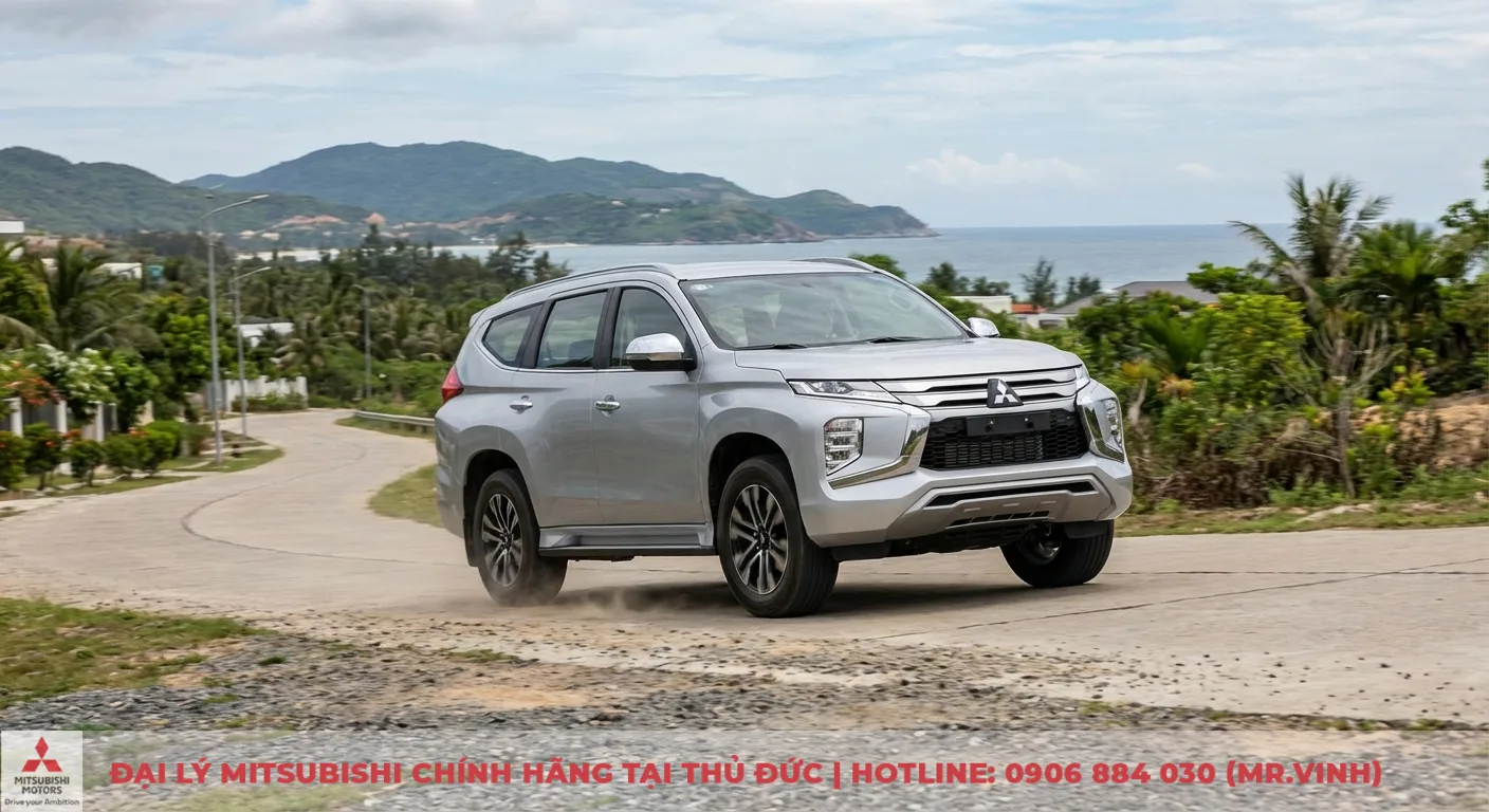 Vận hành Destinator 2026: Giải mã hệ thống và nguyên lý hoạt động 3 Xe SUV màu bạc của Mitsubishi đang di chuyển trên đường cong ven biển, bụi đất bắn ra từ bánh xe thể hiện khả năng xử lý trên địa hình